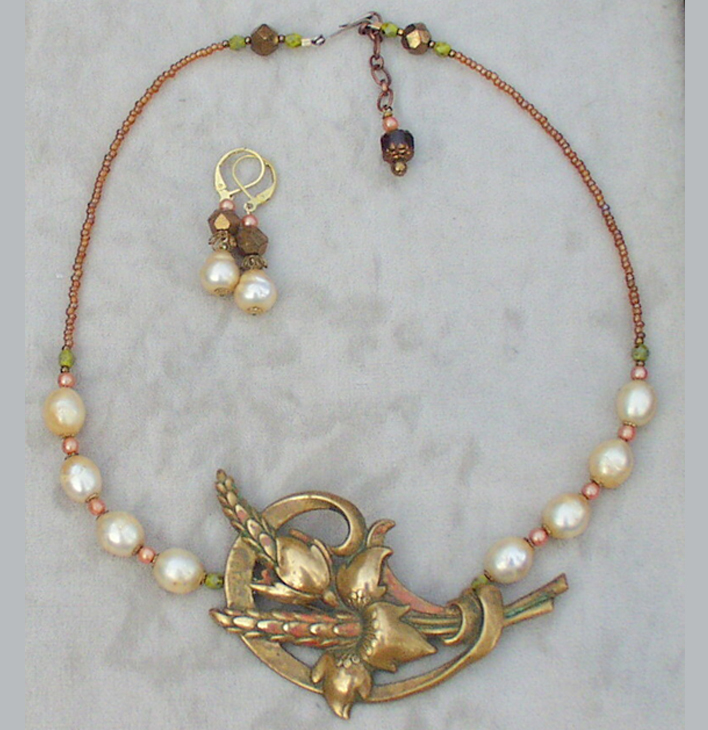 a necklace and earring with a bird on it